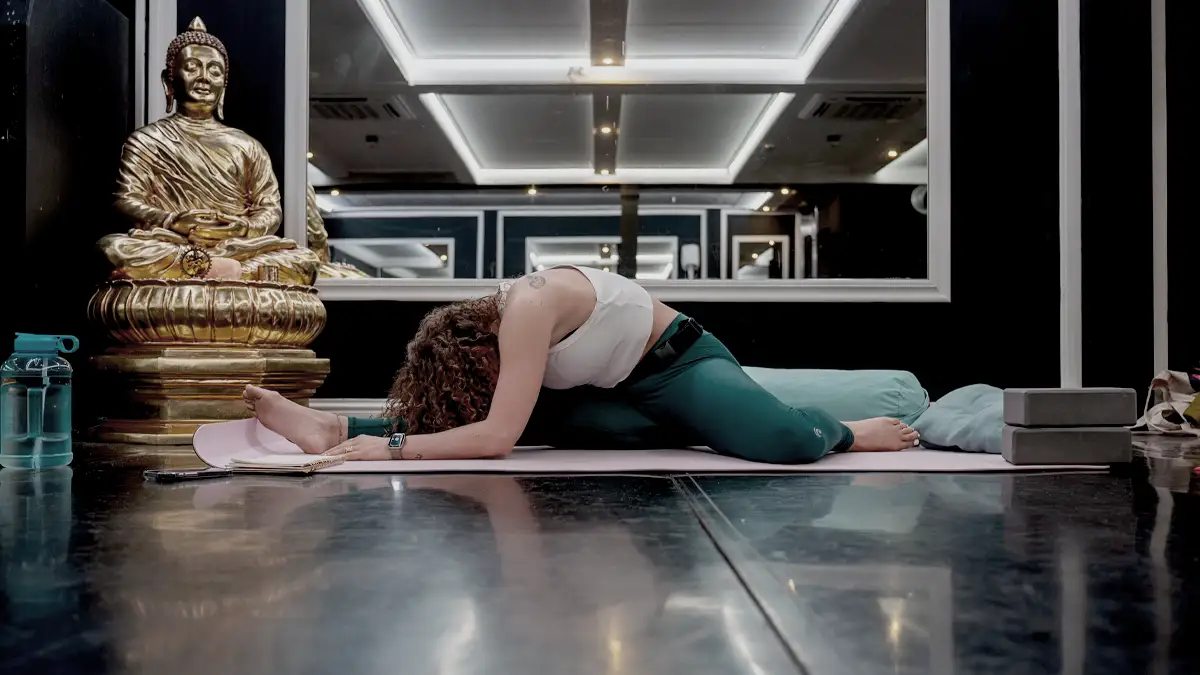 yoga instructrice doet oefening voor tijden yogs les